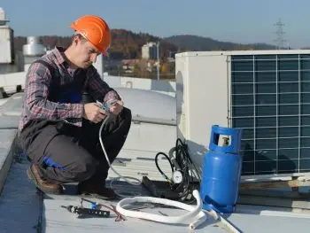 Repair man working on commercial AC Unit