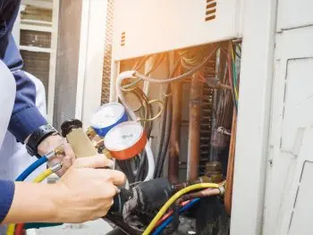 ac technician reading pressure gauges