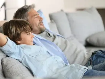 Man and son sitting on couch